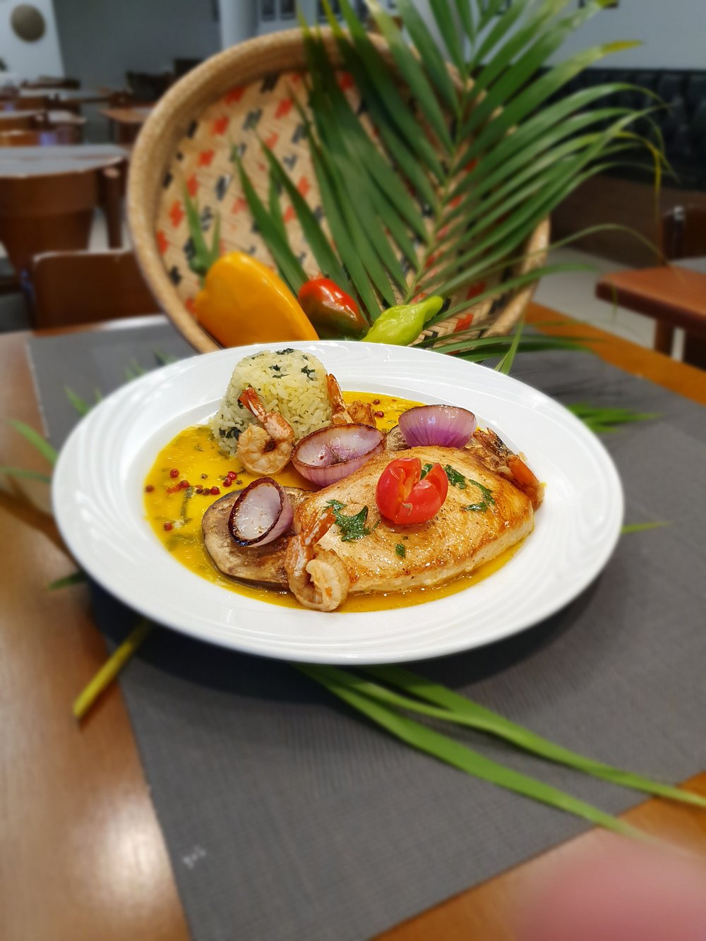 Prato de peixe ao molho amarelo com camarões, arroz e cebola roxa